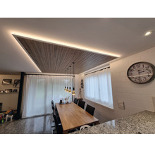 Salle à manger avec table, chaises, panneau de plafond avec éclairage et horloge murale.
