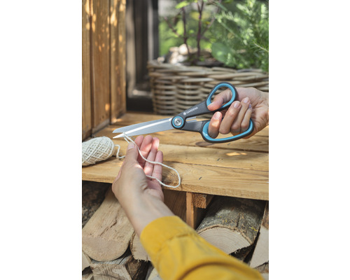 Une personne coupe une ficelle avec des ciseaux universels Gardena.