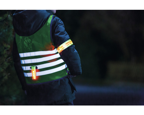 Kind mit reflektierender Sicherheitsweste und Armband für bessere Sichtbarkeit