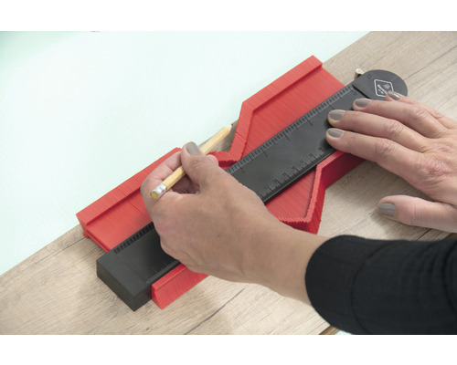 Une personne utilise un gabarit de contour pour transférer des formes.