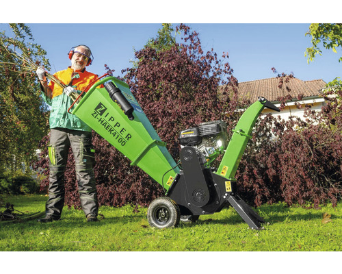 Homme avec broyeur de branches Zipper Logo ZI-HAEK4100 dans le jardin