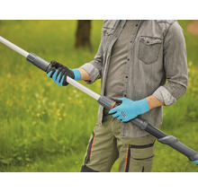 Eine Person mit Gartenhandschuhen hält eine Teleskopstielverlängerung im Freien.