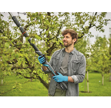 Mann benutzt eine Gardena Akku-Astschere zum Beschneiden von Ästen im Garten.