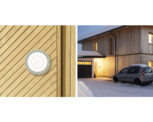 Interrupteur d''éclairage intelligent sur façade en bois et vue d''une maison en hiver