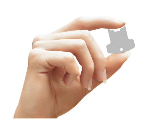 Une main tient un petit disque de marquage