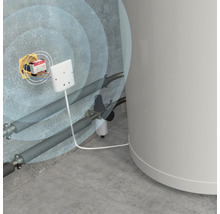Installation d''un détecteur de fuites dans un local de chauffage avec des tuyaux et une chaudière.