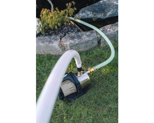 Jardin avec pompe de bassin et tuyaux sur gazon