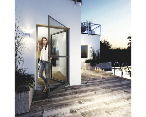 Vue d''une maison moderne avec une porte ouverte et une femme dans l''entrée