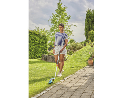 Femme utilisant un coupe-bordures dans le jardin
