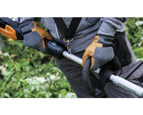 Personne portant des gants de travail utilisant un coupe-bordures