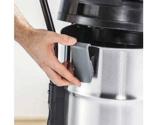 Gros plan d''un aspirateur eau et poussière avec une main actionnant le mécanisme de fermeture