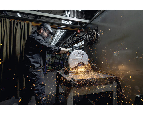 Métallurgiste travaillant avec une scie à métaux de Metabo avec des étincelles