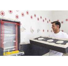 Handwerker bringt Dämmplatten an einer Hauswand an