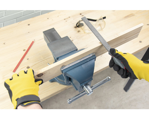 Établi avec étau, planche de bois et lime pour le travail du bois.