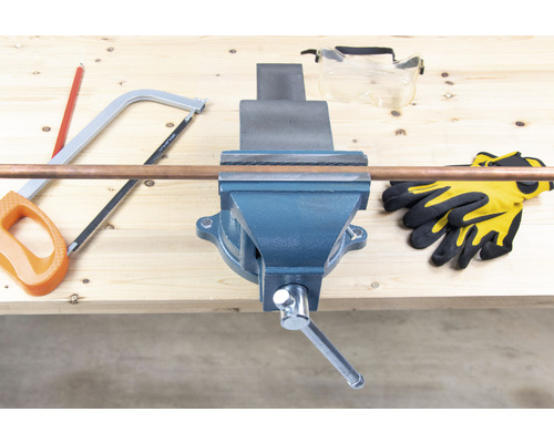 Établi avec étau, tuyau de cuivre, scie, lunettes de protection et gants
