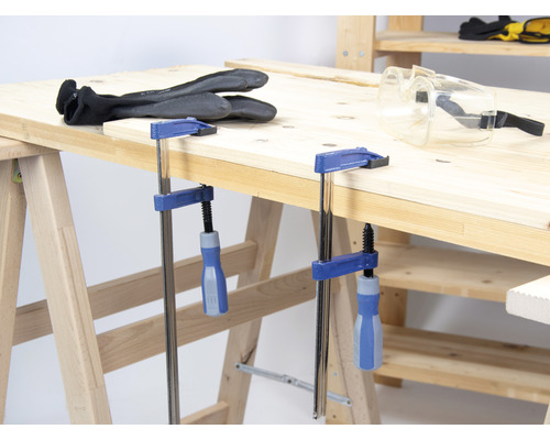 Établi avec serre-joints, lunettes de protection et gants de travail