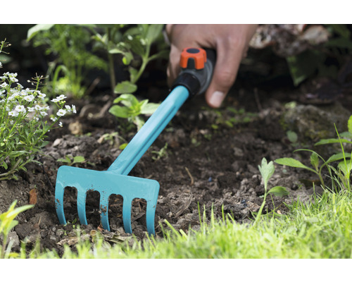 Gartenrechen im Einsatz im Beet