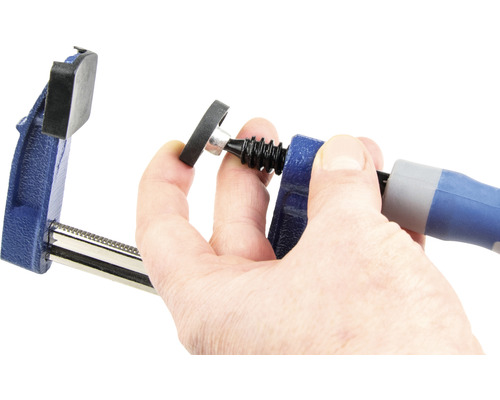 Un serre-joint est actionné par une main.