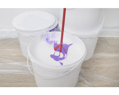 Mélangeur de peinture dans un seau de peinture avec de la peinture