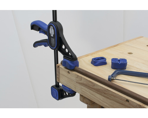 Fixation de tuyau avec une pince à tube sur un établi, avec une scie à métaux et des supports de tuyau