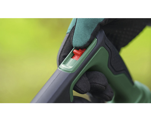 Gros plan sur la manipulation d'un outil de jardin avec un interrupteur rouge