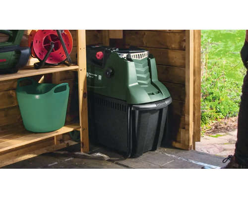 Scène de jardin avec tondeuse à gazon dans un cabanon en bois