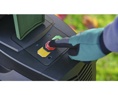 Une main gantée appuie sur le bouton d''arrêt rouge d''un outil de jardin.