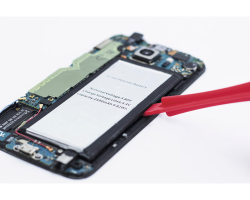 Geöffnetes Smartphone mit herausgenommener Batterie und rotem Werkzeug