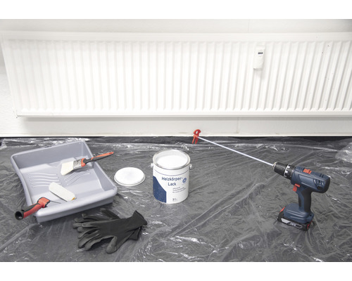Scène avec vernis pour radiateur, bac à peinture, pinceau, rouleau à peinture, visseuse sans fil et gants de protection pour peindre le radiateur