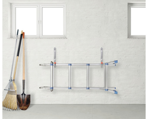 Aufbewahrung von Gartengeräten und einer Leiter an einer Wand.