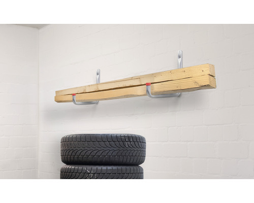 Holzbretter an Wandhaken und gestapelte Reifen