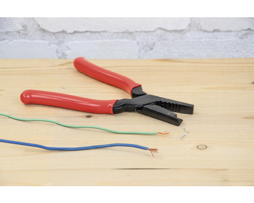 Pince à dénuder avec câbles électriques sur une table en bois
