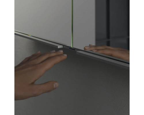 Vue détaillée d''une armoire de toilette avec une main devant la surface du miroir