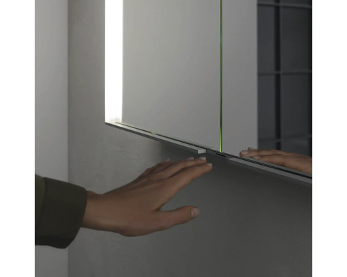 Gros plan d''une armoire de toilette avec une main la touchant.