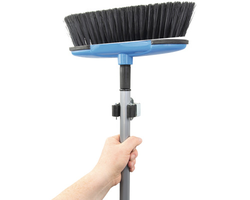 Main tenant un balai avec manche télescopique