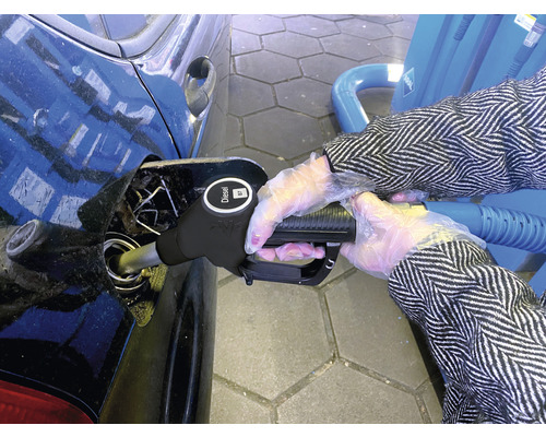 Une personne fait le plein de diesel dans une voiture à une station-service