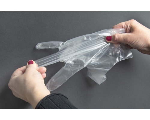 Une femme met un gant jetable transparent