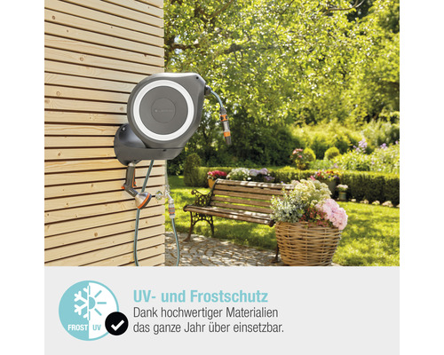 Tuyau d''arrosage enroulé avec buse de pulvérisation sur un mur en bois dans le jardin