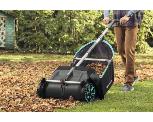 Une personne utilise un collecteur de feuilles Gardena dans le jardin pour ramasser les feuilles d''automne.