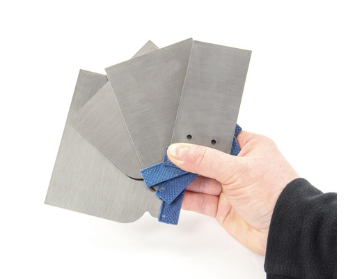 Une main tient un set de différentes spatules en métal