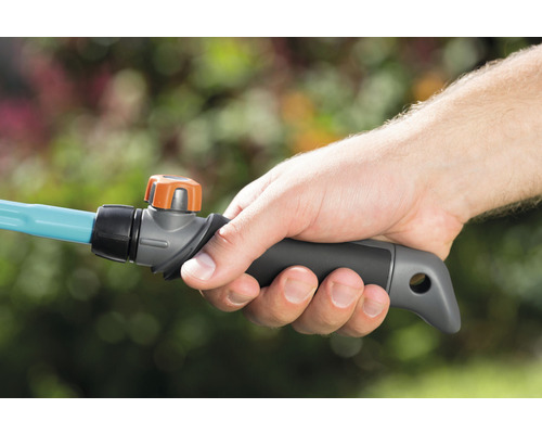 Eine Hand hält einen Gartenschlauch mit Absperrventil.