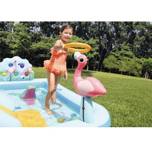 Enfant jouant avec pataugeoire gonflable avec motif flamant rose dans le jardin