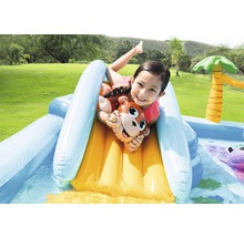 Enfant glissant sur un toboggan aquatique gonflable avec motif de singe dans la pataugeoire