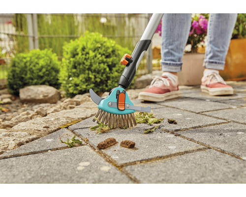 Fugenbürste mit Teleskopstiel im Einsatz auf Pflastersteinen zur Unkrautentfernung