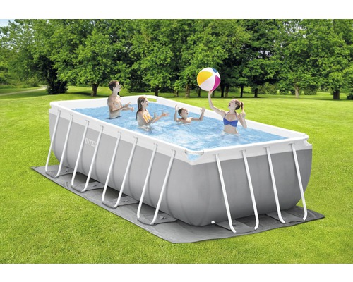 Piscine rectangulaire avec structure en acier et personnes jouant dans le jardin