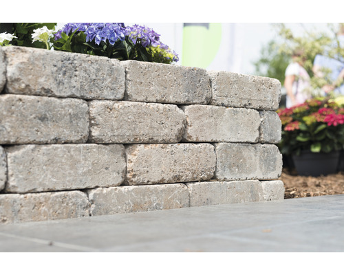 Mauer aus Betonsteinen mit Blumenbepflanzung