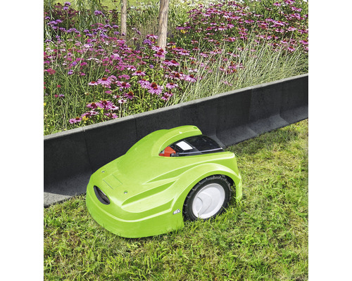 Grüner Rasenmähroboter auf Rasenfläche neben Rasenkantensteinen