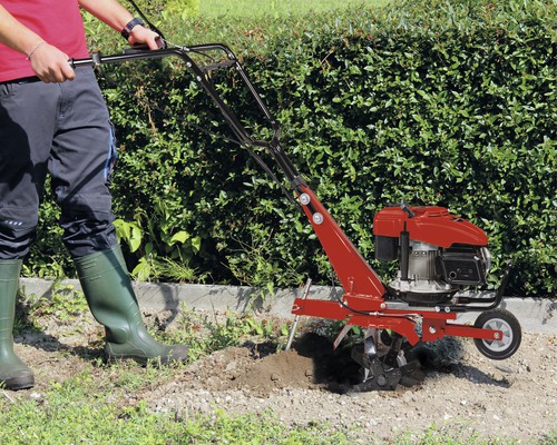 Motobineuse travaillant le sol dans le jardin