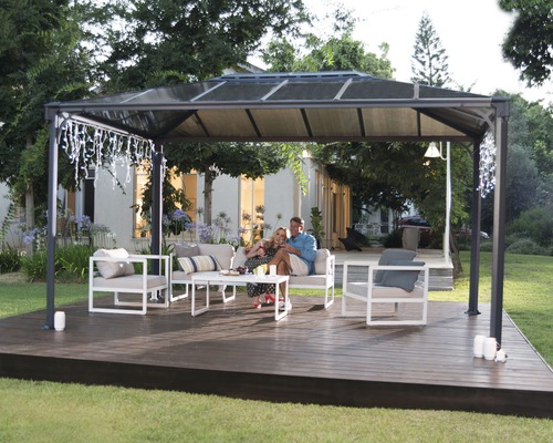 Pavillon autoportant avec coin salon sur une terrasse en bois dans le jardin.