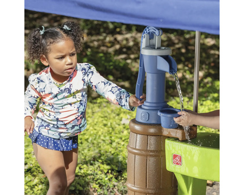 Une fille joue avec une table d''eau Step2 à l''extérieur